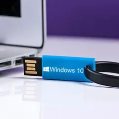Niebieski pendrive z logo Windows 10 podłączony do laptopa.
