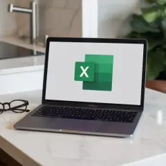 Laptop z logo Excel, gotowy do pracy nad mnożeniem w arkuszu kalkulacyjnym. Obok okulary.
