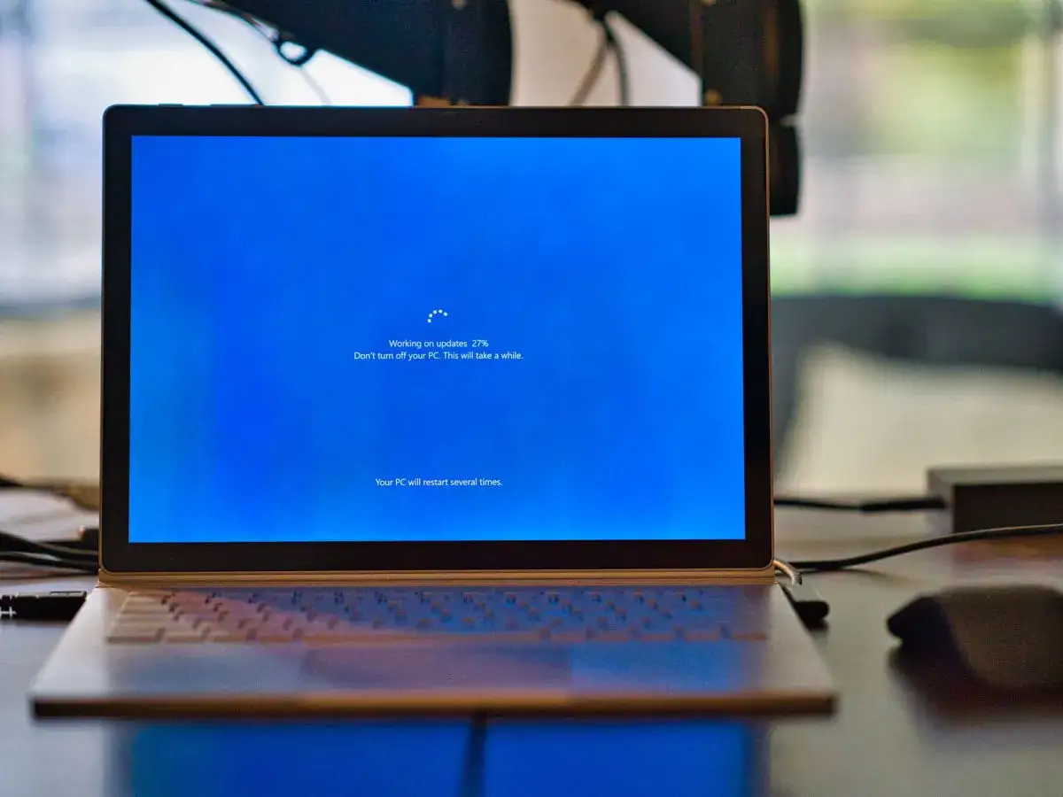 Laptop z ekranem informującym o aktualizacji systemu Windows 11 Pro N. Postęp 27%.